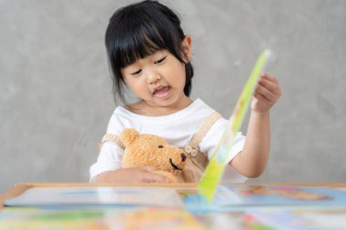 Mutlu Asyalı çocuklar evde kitap okuyarak rahatlar. Kızım ve bir hikaye okuyordum. öğrenme, çocuk bakımı, gülme, eğitim, hikaye anlatma, uygulama, hayal etme, bağımlılık cep telefonunu azaltma