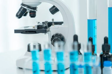 Bilimadamı ileri bilimsel laboratuvarda biyokimyasal örnekleri analiz ediyor. Tıbbi profesyonel kullanım mikroskobu virüsün mikrobiyolojik gelişimini gösteriyor. Fen laboratuvarında biyoteknoloji araştırması