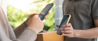 Mutlu Asyalı kadın ödeme için QR kodunu tarıyor. Teslimatçı ekspres teslimat gönderdi. Çevrimiçi dükkan, kağıt konteynır, paket servis, paket, elektronik para, dijital transfer