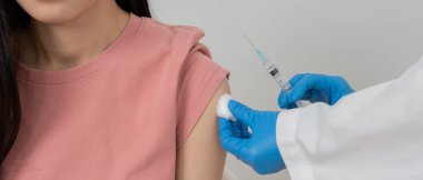 Kadın salgını önlemek için aşı oluyor. Tıp merkezindeki bir hemşire ya da doktordan bir doz bağışıklık aşısı al. Temel aşı, alternatif aşı, risk grubu aşısı.