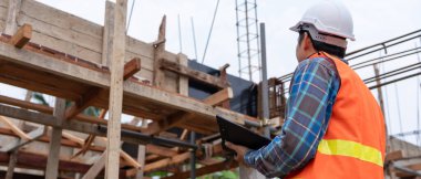 inspector or engineer is inspecting construction and quality assurance new house using a checklist. Engineers or architects or contactor work to build the house before handing it over to the homeowne