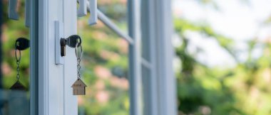 Landlord key for unlocking house is plugged into the door. Second hand house for rent and sale. keychain is blowing in the wind. mortgage for new home, buy, sell, renovate, investment, owner, estat