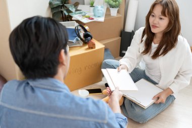 Taşınmak, taşınmak. Mutlu ve gülümseyen bir çift yeni daire için mobilyaları yerleştirir ve taşır. Odanın içinde kişisel eşyalar içeren bir karton kutu vardı. yeni daireye taşın