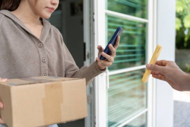 Mutlu Asyalı kadın ödeme için QR kodunu tarıyor. Teslimatçı ekspres teslimat gönderdi. Çevrimiçi dükkan, kağıt konteynır, paket servis, paket, elektronik para, dijital transfer