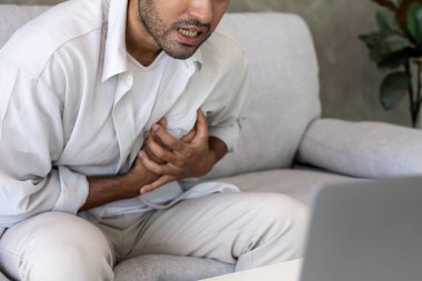 Göğüs kafesinde kalp krizi belirtileri var. Asyalı bir adamın göğüs ağrısı var. Kalp hastalığından, sızıntıdan, genişlemeden, genişlemiş kalp krizinden, göğsüne acı veren bir ifadeyle bastırılmış.