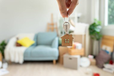 Moving house, relocation. Man hold key house keychain in new apartment. move in new home. Buy or rent real estate. flat tenancy, leasehold property, new landlord, investment, dwelling, loan, mortgage.
