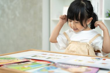Mutlu Asyalı çocuklar rahatlayın ayı bebek için masal kitabı okuyun. Kızım ve bir hikaye okuyordum. öğrenim geliştirme, çocuk bakımı, eğitim, hikaye anlatma, uygulama, hayal etme, bağımlılığı azaltma cep telefonu