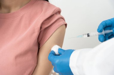 Kadın salgını önlemek için aşı oluyor. Tıp merkezindeki bir hemşire ya da doktordan bir doz bağışıklık aşısı al. Temel aşı, alternatif aşı, risk grubu aşısı.