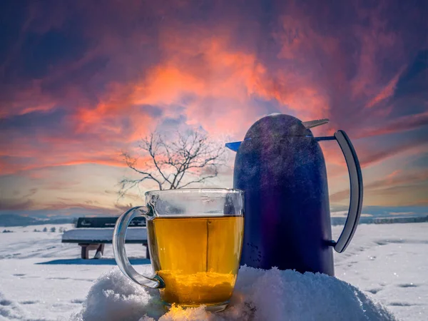 fresh tea with thermos in a winter landscape