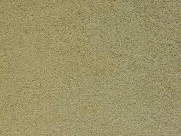 Textured plaster on a wall in the color yellow, texture background