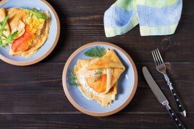 Krem peynirli krep, füme somon balığı ve çırpılmış yumurta ve somonla sarılmış pankace. Krep. Yüksek açı görünümü