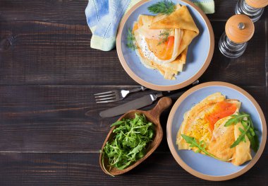 Krem peynirli krep, füme somon balığı ve çırpılmış yumurta ve somonla sarılmış pankace. Krep. Yüksek açı görünümü