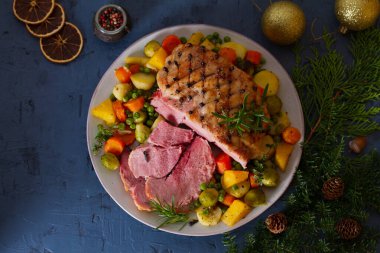 Patates, havuç, şalgam ve brunsel filizli karanfil pişirilmiş jambon. Noel süsleri. Yeni yıl yemeği masası. Yukarıdan bak, en iyi stüdyo çekimi. 