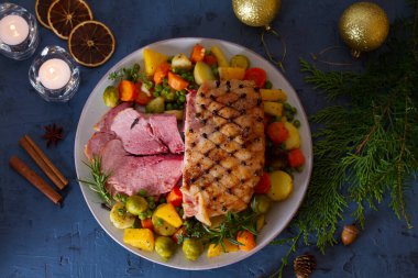 Patates, havuç, şalgam ve brunsel filizli karanfil pişirilmiş jambon. Noel süsleri. Yeni yıl yemeği masası. Yukarıdan bak, en iyi stüdyo çekimi. 