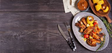 Izgara domuz pirzolası ve ahşap arka planda sebze ve fotokopi alanı. Yüksek açı görünümü