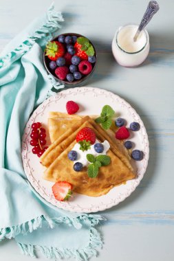 Krep, yoğurt ve böğürtlenli krep yığını. Fotokopi alanı olan bir tabağa sarılmış gözleme. Yüksek açı görünümü