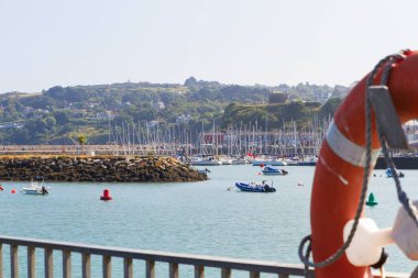Lifebuoy ve manzara gezinti güvertesinden marina ve Howth 'a, Howth Yarımadası Dublin İrlanda' sında bir İrlanda kasabası. Sakin mavi deniz manzarası ve berrak gökyüzü 