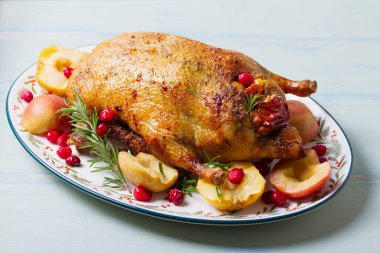 Elma ve kızılcıklı kızarmış ördek bezelye, kırmızı lahana ve patatesle servis edilir.