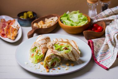 Hindi tabağa ve malzemeler masaya konur. Tortilla, burrito, sandviç, karışık börek.