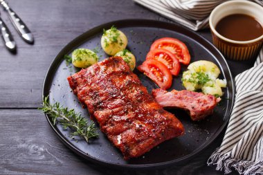 Siyah tabakta patates ve lahana salatası.