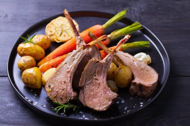 Kızarmış kuzu pirzolası. Siyah tabakta sebzeli kuzu pirzolası