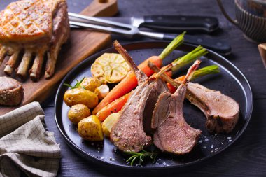 Kızarmış kuzu pirzolası. Siyah tabakta sebzeli kuzu pirzolası