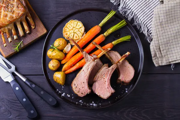 Kızarmış kuzu pirzolası. Siyah tabakta sebzeli kuzu pirzolası. Yukarıdan görüntüle, en üstten 