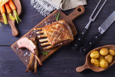 Kızarmış kuzu pirzolası. Tahta üzerinde sebzeli kuzu pirzolası. Yukarıdan görüntüle, en üstten 