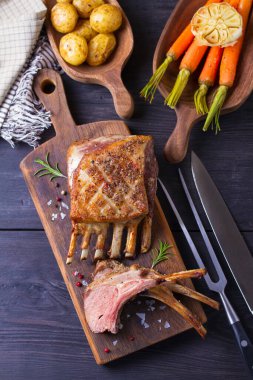 Kızarmış kuzu pirzolası. Tahta üzerinde sebzeli kuzu pirzolası. Yukarıdan görüntüle, en üstten 