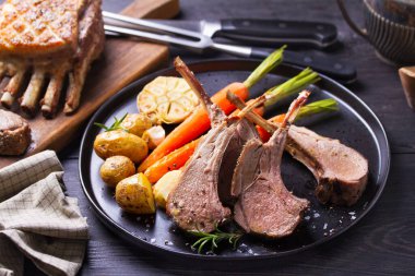 Havuçlu ve patatesli kuzu pirzola, siyah arka plan. Kızarmış kuzu pirzolası