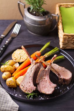 Havuçlu ve patatesli kuzu pirzola, siyah arka plan. Kızarmış kuzu pirzolası