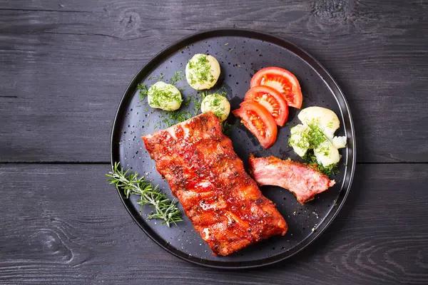 Izgara domuz pirzolası, haşlanmış patates ve taze sebze, siyah arka plan. Yüksek açı görünümü