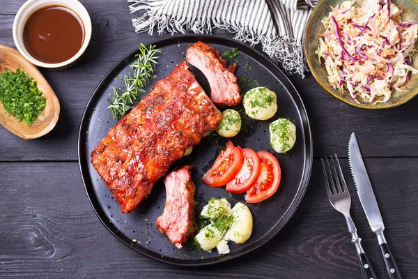 Izgara domuz pirzolası, haşlanmış patates ve taze sebze, siyah arka plan. Yüksek açı görünümü