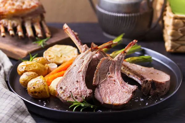 Havuçlu ve patatesli kuzu pirzola, siyah arka plan. Kızarmış kuzu pirzolası