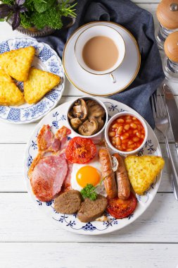 Sosis, domuz pastırması, puding, yumurtanın sarısı, patates kızartması, fasulye ve domatesli tam İrlanda kahvaltısı. Yukarıdan bak, en iyi stüdyo çekimi.