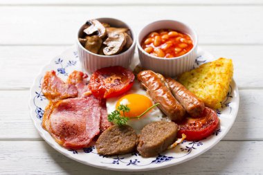 Sosis, domuz pastırması, puding, yumurta sarısı, patates, fasulye ve domatesli tam İrlanda kahvaltısı.