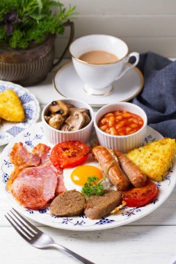 Sosis, domuz pastırması, puding, yumurta sarısı, patates, fasulye ve domatesli tam İrlanda kahvaltısı.