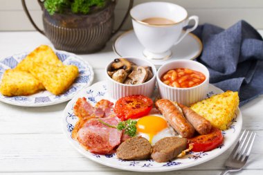Sosis, domuz pastırması, puding, yumurta sarısı, patates, fasulye ve domatesli tam İrlanda kahvaltısı.