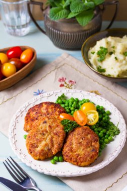 Beyaz tabakta sebzeli balık burgeri. Balık köftesi mi kek mi?