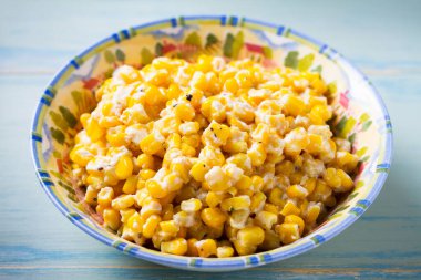 Lezzetli tereyağlı tatlı mısır kasesinde mavi ahşap arka planda