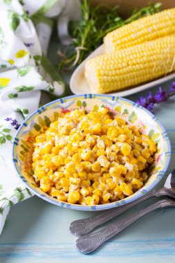 Lezzetli tereyağlı tatlı mısır kasesinde mavi ahşap arka planda