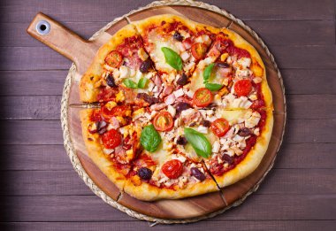 Eritilmiş peynirli pizza, kıtır kıtır, üzerine zeytin ve fesleğen yaprağı konmuş. Yüksek açı görünümü