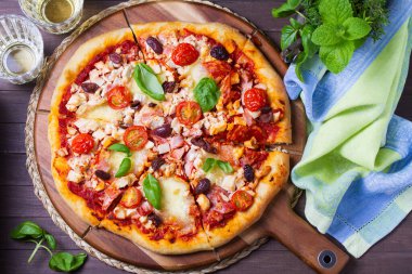 Eritilmiş peynirli pizza, kıtır kıtır, üzerine zeytin ve fesleğen yaprağı konmuş. Yüksek açı görünümü