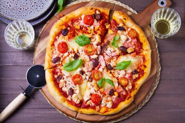 Eritilmiş peynirli pizza, kıtır kıtır, üzerine zeytin ve fesleğen yaprağı konmuş. Yüksek açı görünümü