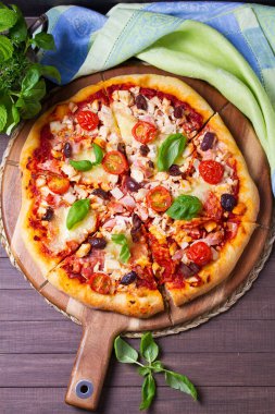 Eritilmiş peynirli pizza, kıtır kıtır, üzerine zeytin ve fesleğen yaprağı konmuş. Yüksek açı görünümü