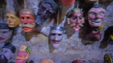 Weird Traditional Latin American Masks grouped in Cave Rock Wall, Traditional Masks from Guatemalan Culture hung against a Cave Rock Wall. High quality 4k footage