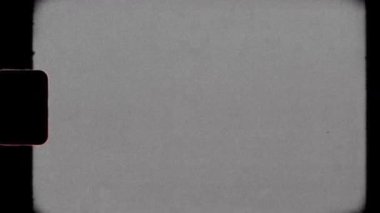 Vintage 8mm Film Grain Overlay with Overexposed Glow, Letterbox Frame, Super-8 Sprocket, Flicker, Dust, and Analog Fading. High quality 4k footage