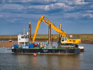 Kuyu, Norfolk, İngiltere Limanı 'nda, derinlik izleme teknolojisi ve uzun menzilli JCB çapası ile 20 metreye 10 metre boyunda bir spud-leg dubası olan dredger Kari Hege limanında.