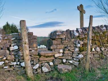 Derbyshire, İngiltere 'de, kuru bir taş duvarın üzerinde geleneksel bir taş dikişi. Kışın güneşli bir günün sonunda çekildi..