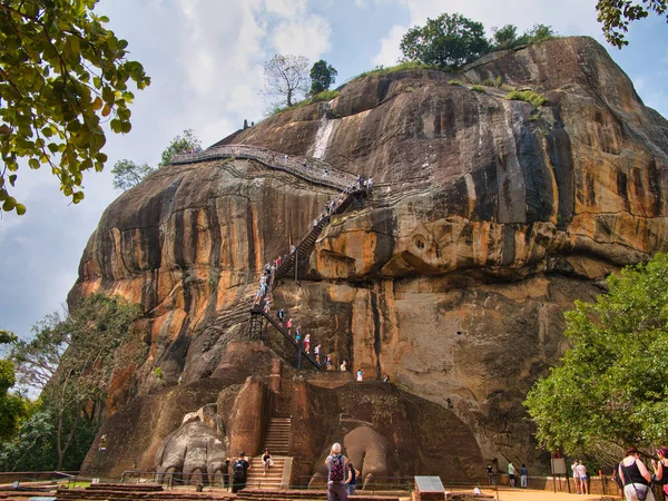 ライオンゲートの上には多くの観光客が登り スリランカ中央部のシギリヤまたはライオンロックの古代の岩の要塞の上に急な階段を下ります — ストック写真